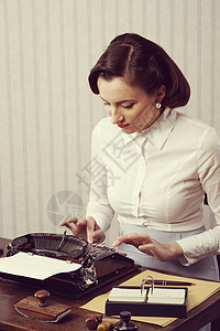 女性在办公室打字人士收腰桌子复古打字机秘书女子复兴风格邮票背景图片