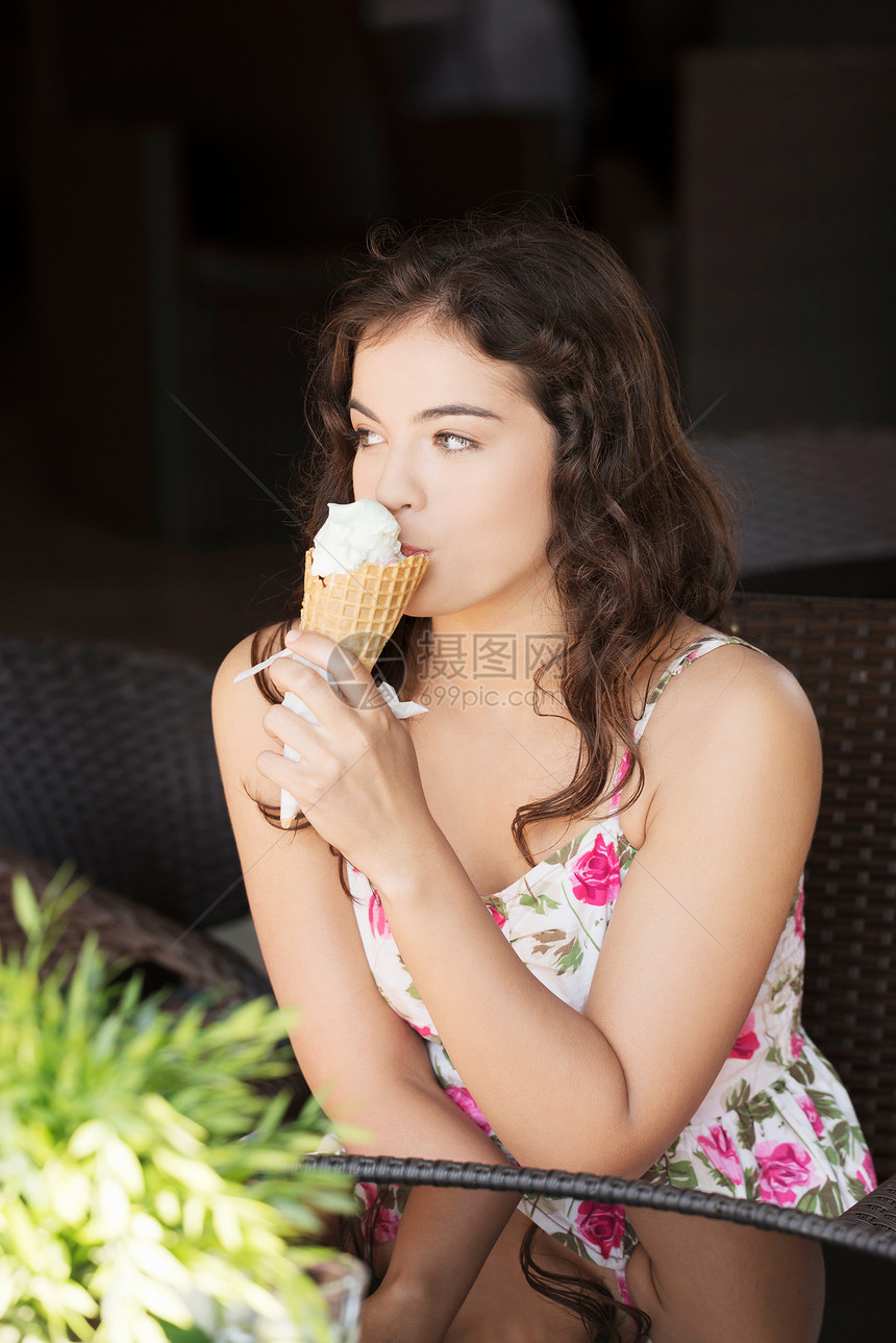 年轻的快乐女人吃冰淇淋的肖像享受闲暇乐趣城市甜点奶油晴天喜悦女孩女士图片