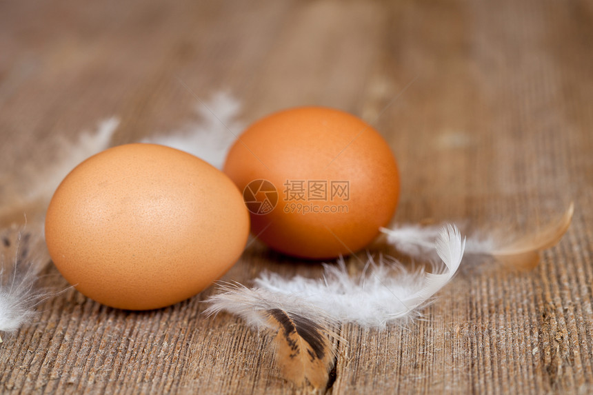 两个鸡蛋和羽毛食物厨房棕色乡村木头桌子白色营养斑点图片