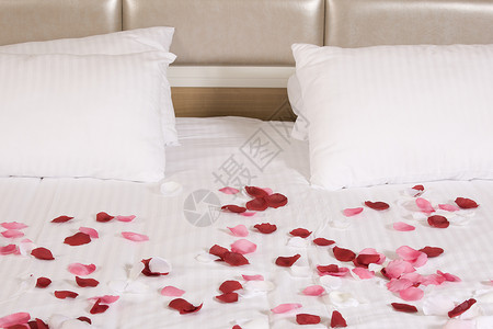 带有大床和红花的旅馆客房酒店枕头玫瑰住宅寝具毯子房子奢华白色家具背景图片