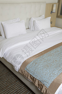 在豪华酒店房间的国王大床床垫旅行床头床单陈列柜水平摄影场景墙纸枕头背景图片