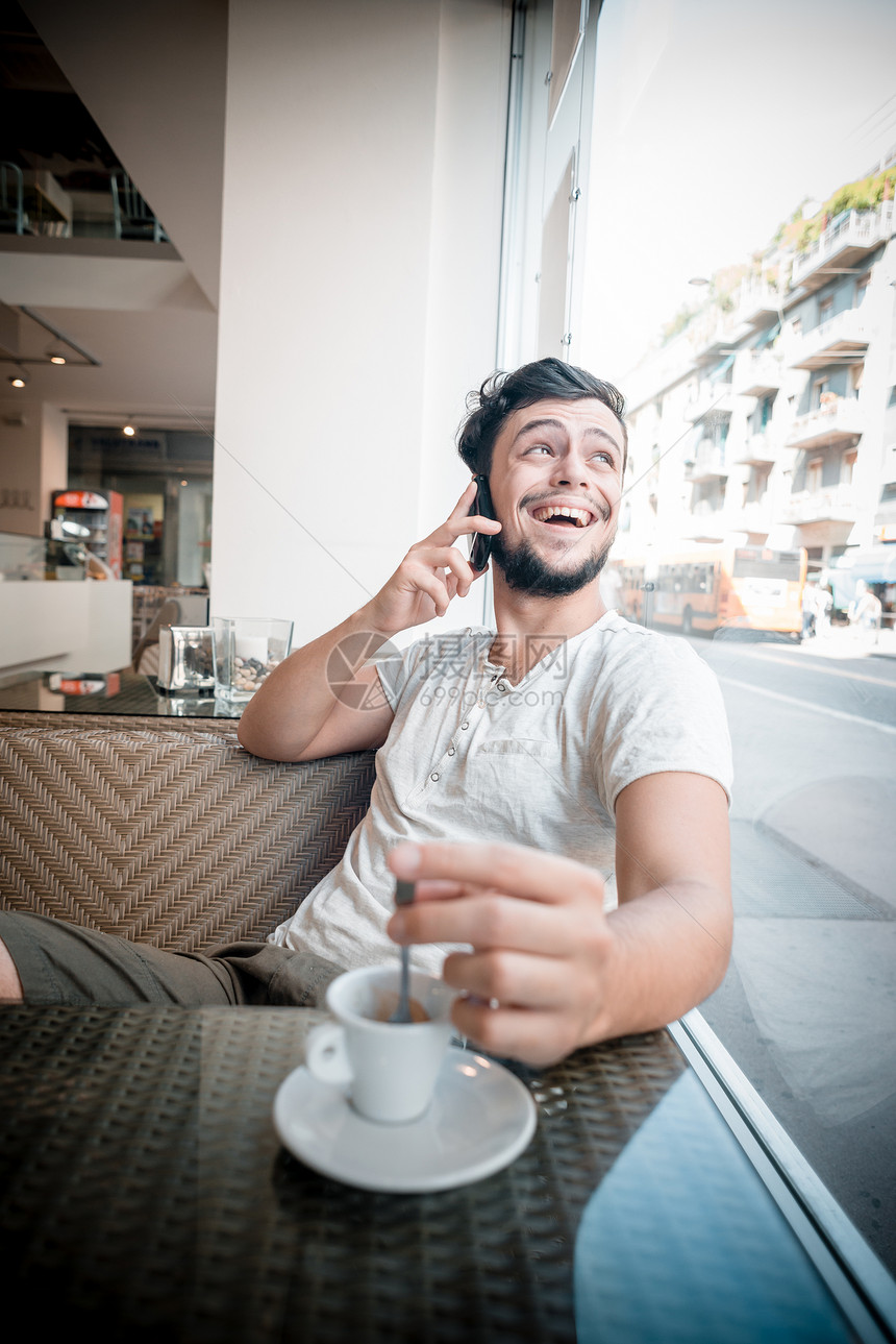 酒吧里的年轻时尚男子短信咖啡窗户潮人手机写作沟通日常生活年轻人休息图片