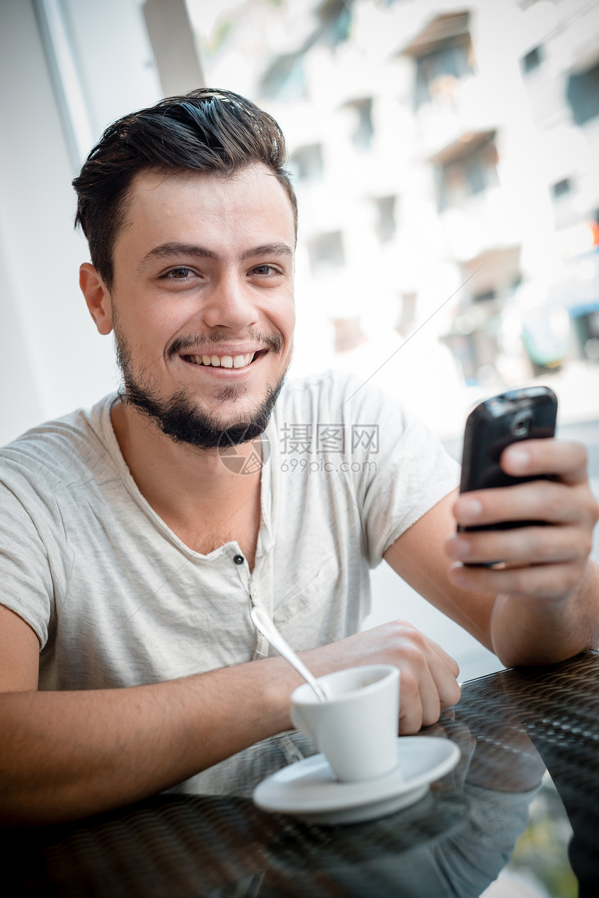 酒吧里的年轻时尚男子日常生活沟通手机年轻人休息潮人咖啡短信写作窗户图片