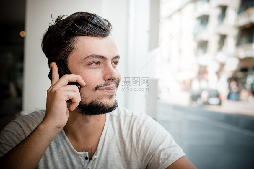酒吧里的年轻时尚男子沟通咖啡潮人日常生活窗户休息写作手机短信年轻人图片