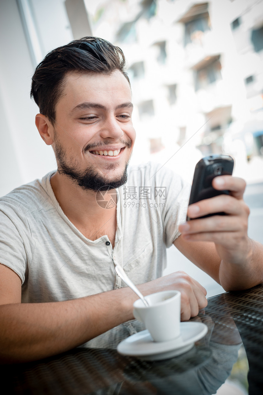 酒吧里的年轻时尚男子啤酒写作潮人窗户手机沟通休息日常生活短信咖啡图片