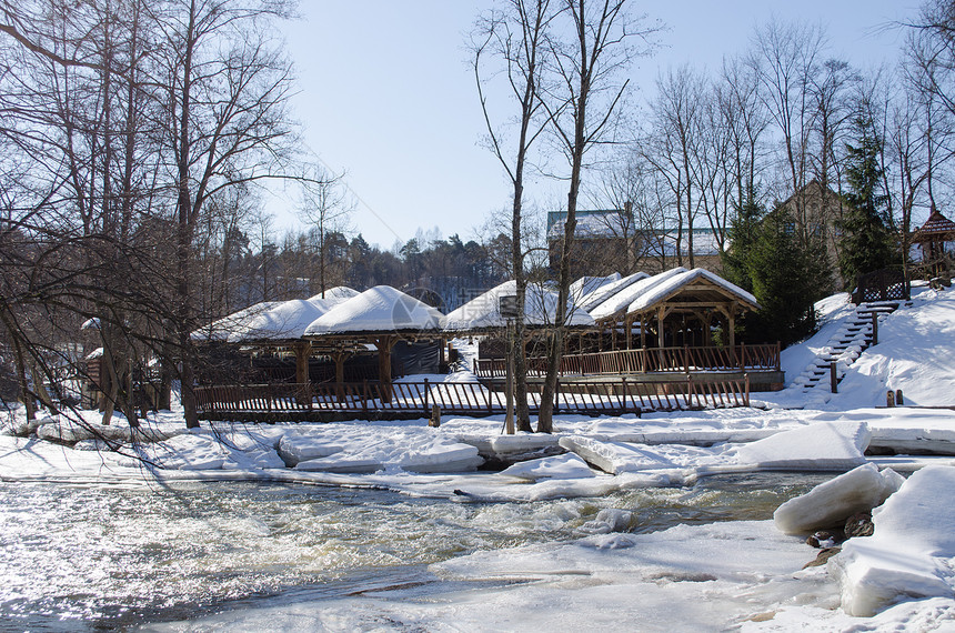 冷冻的河岸冻结的木制村庄房屋屋顶雪图片