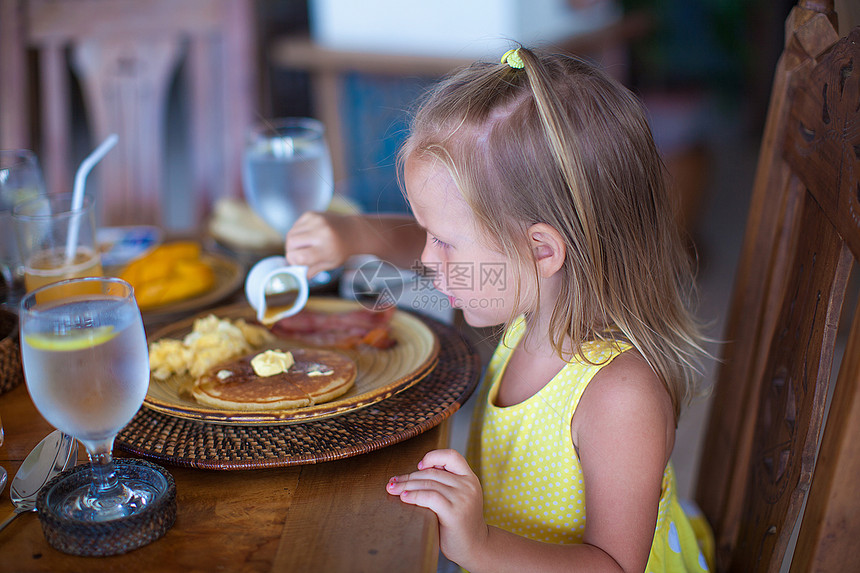 可爱的小女孩在度假餐厅吃早饭 很可爱早餐童年孩子黄色果汁柠檬食物女孩女性假期图片