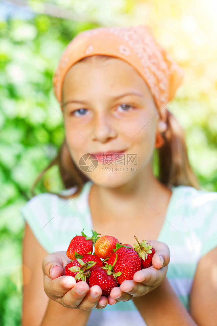 女孩拿着草莓孩子马尾辫快乐花园食物小吃水果浆果诱惑微笑图片