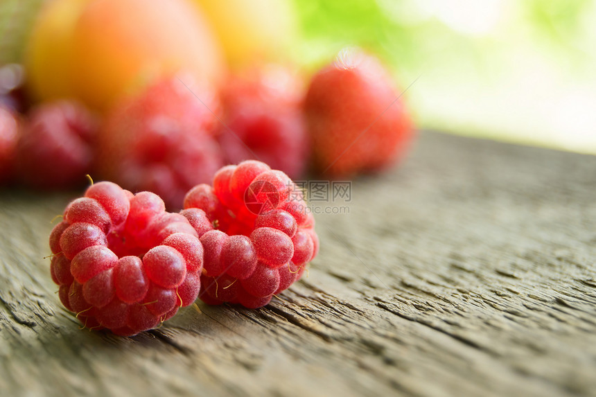 木制桌边的甜莓果和水果图片