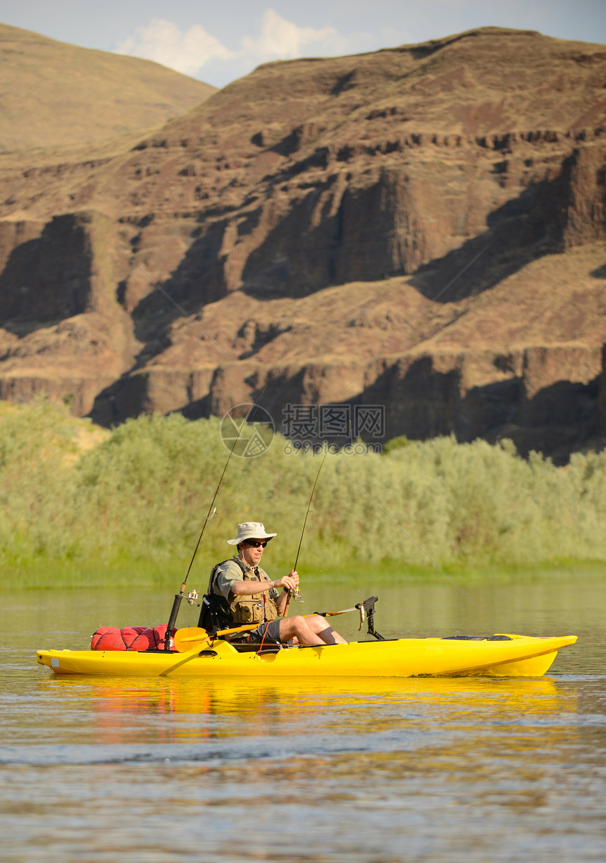 夏天在河边的一条皮艇上钓鱼的人图片