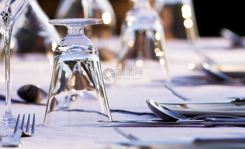 高级餐厅餐桌设置银器反射午餐刀具桌布用餐机构环境白色桌子图片