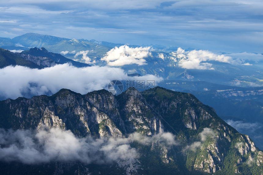 在意大利山高的云中岩石蓝色爬坡多云乡村顶峰阳光旅行戏剧性场景图片