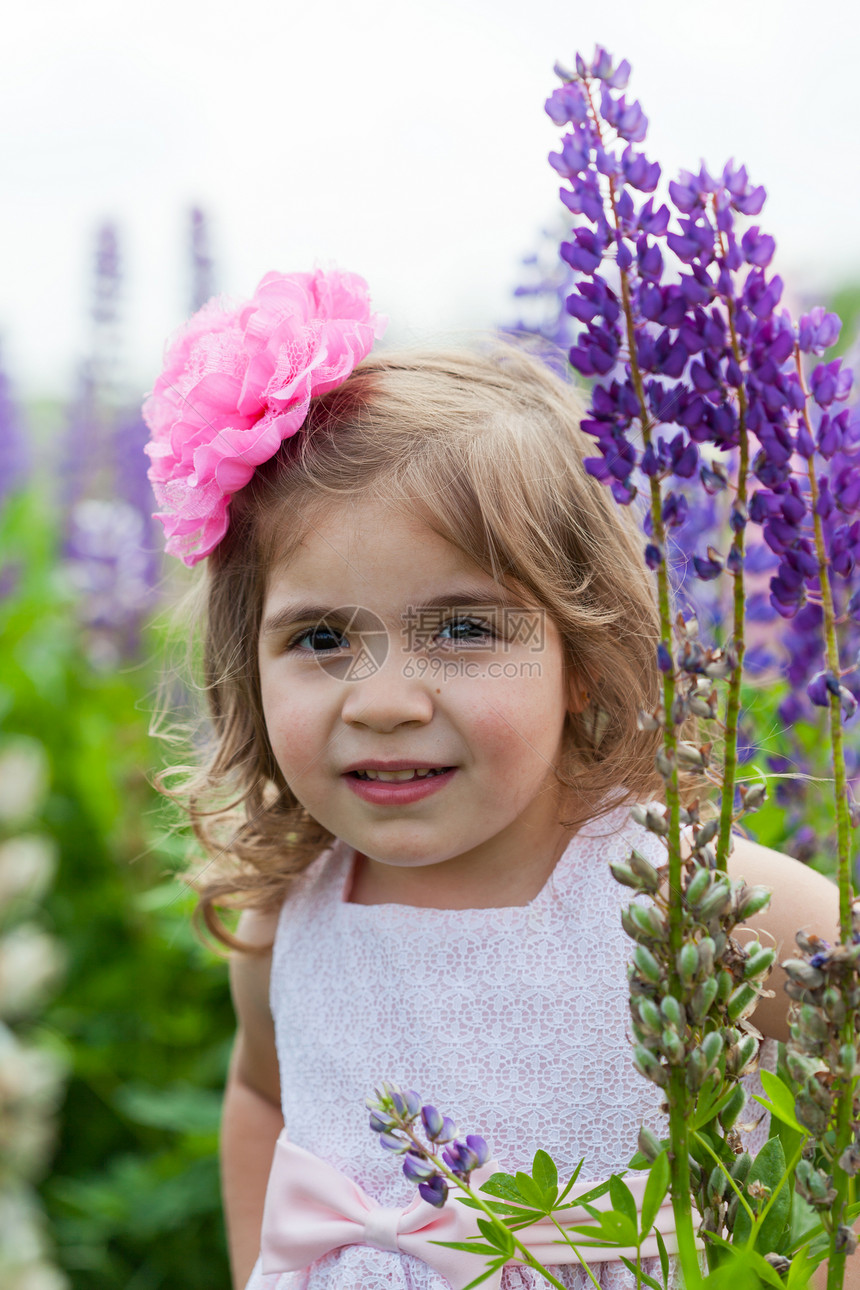 女孩站在开花的乳房中间孩子太阳能村庄乐趣草地幸福场地粉色花朵日光图片
