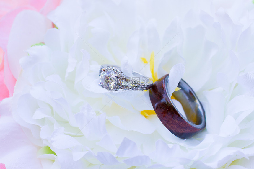 花朵上的结婚戒指钻石婚姻结婚戒指婚礼已婚夫妻木纹珠宝木头图片