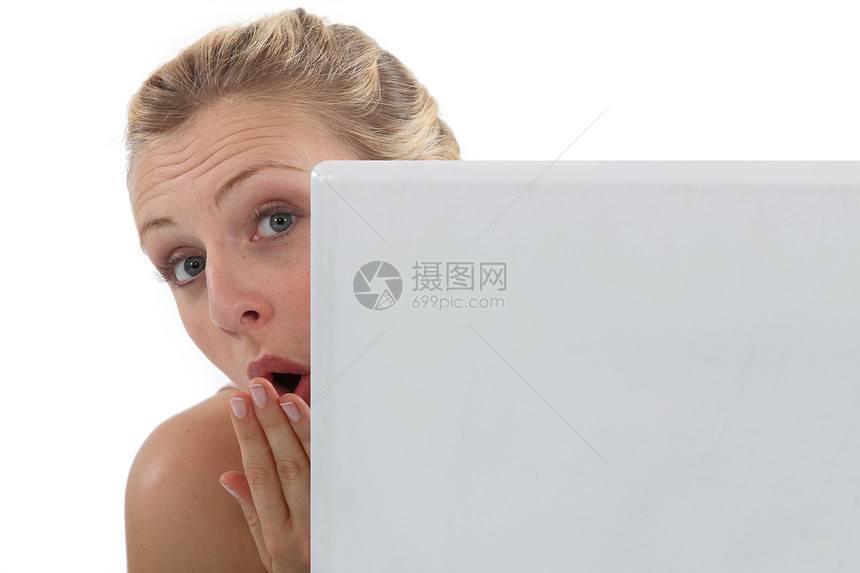 惊讶的女人从她的笔记本电脑后面图片