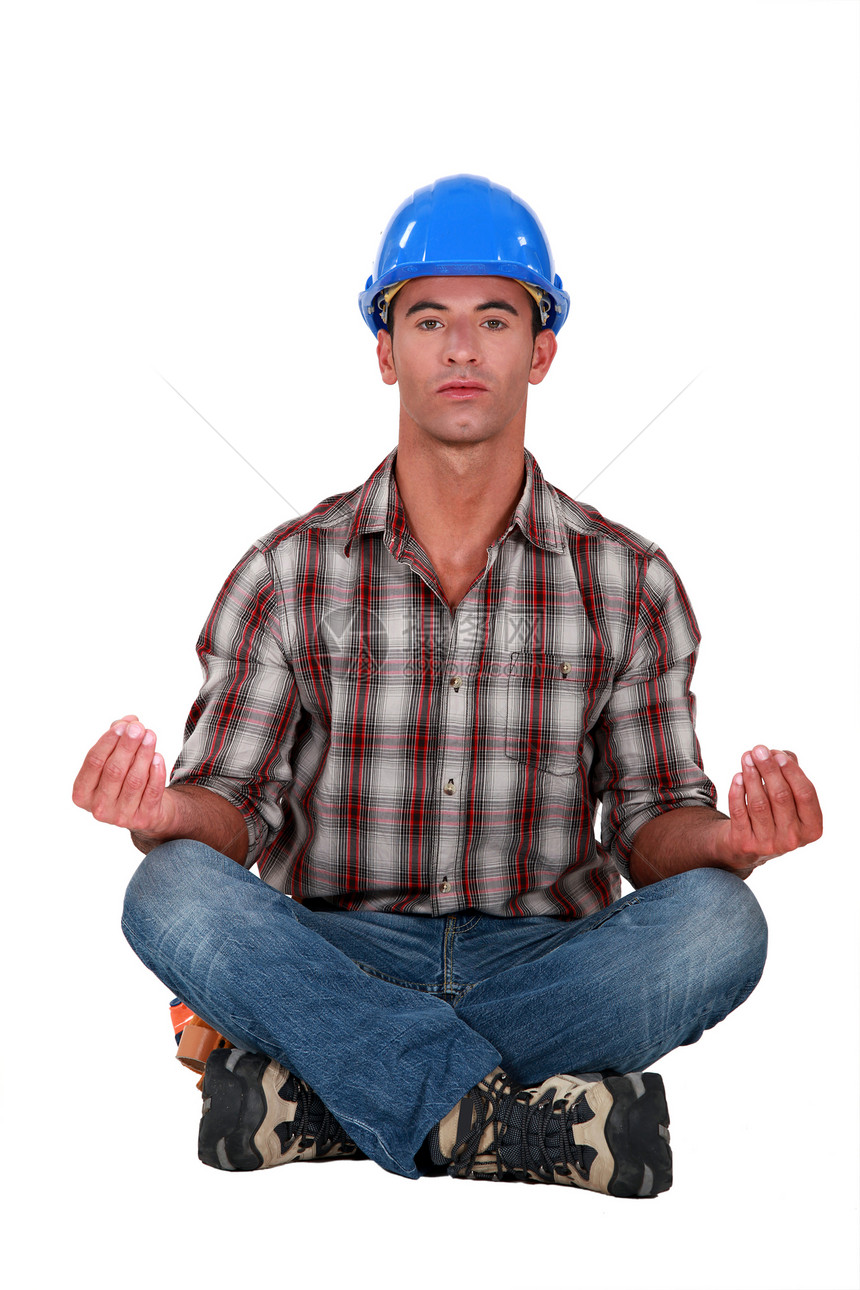 一个男性建筑工人 处于瑜伽位置图片
