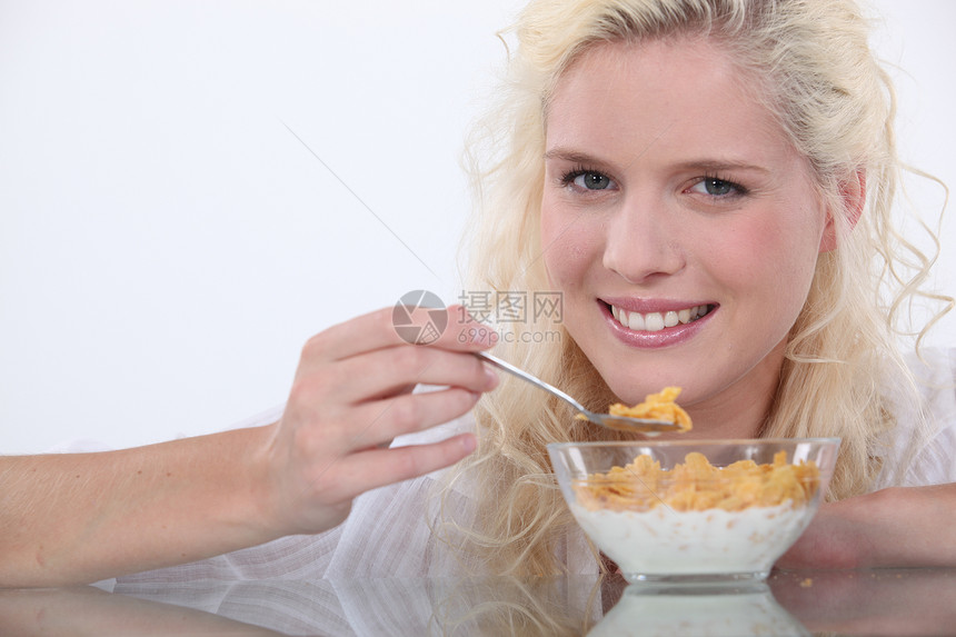 年轻妇女用牛奶吃谷类食品图片