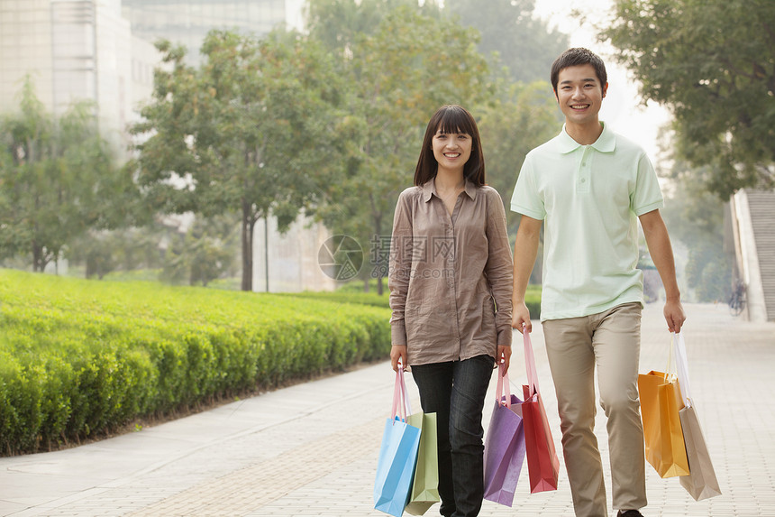 年轻夫妇手握着购物袋走路 中国北京零售男朋友衬衫团结女性摄影纽扣短发服装活动图片