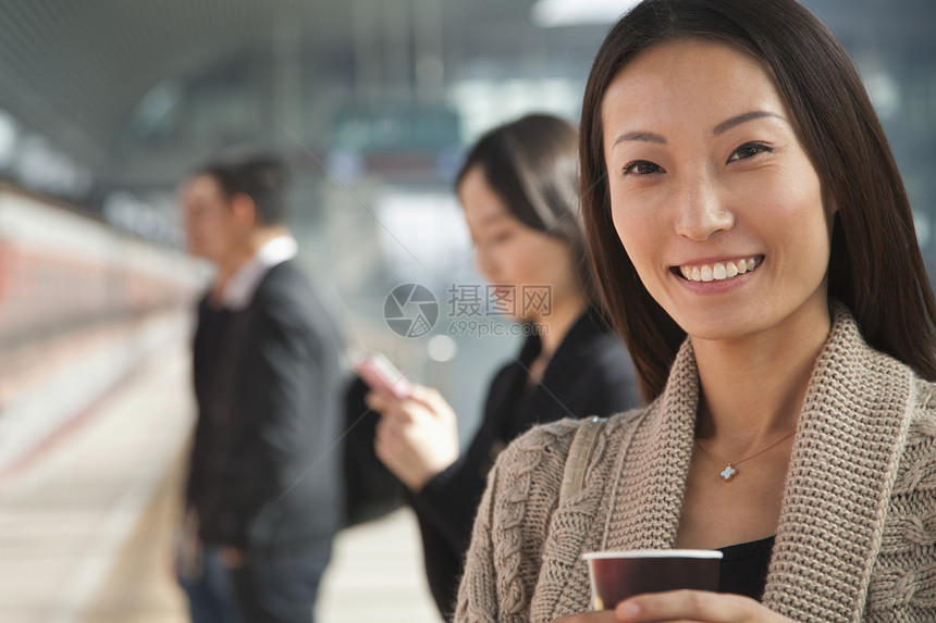 青年女子与咖啡在火车平台上等待图片