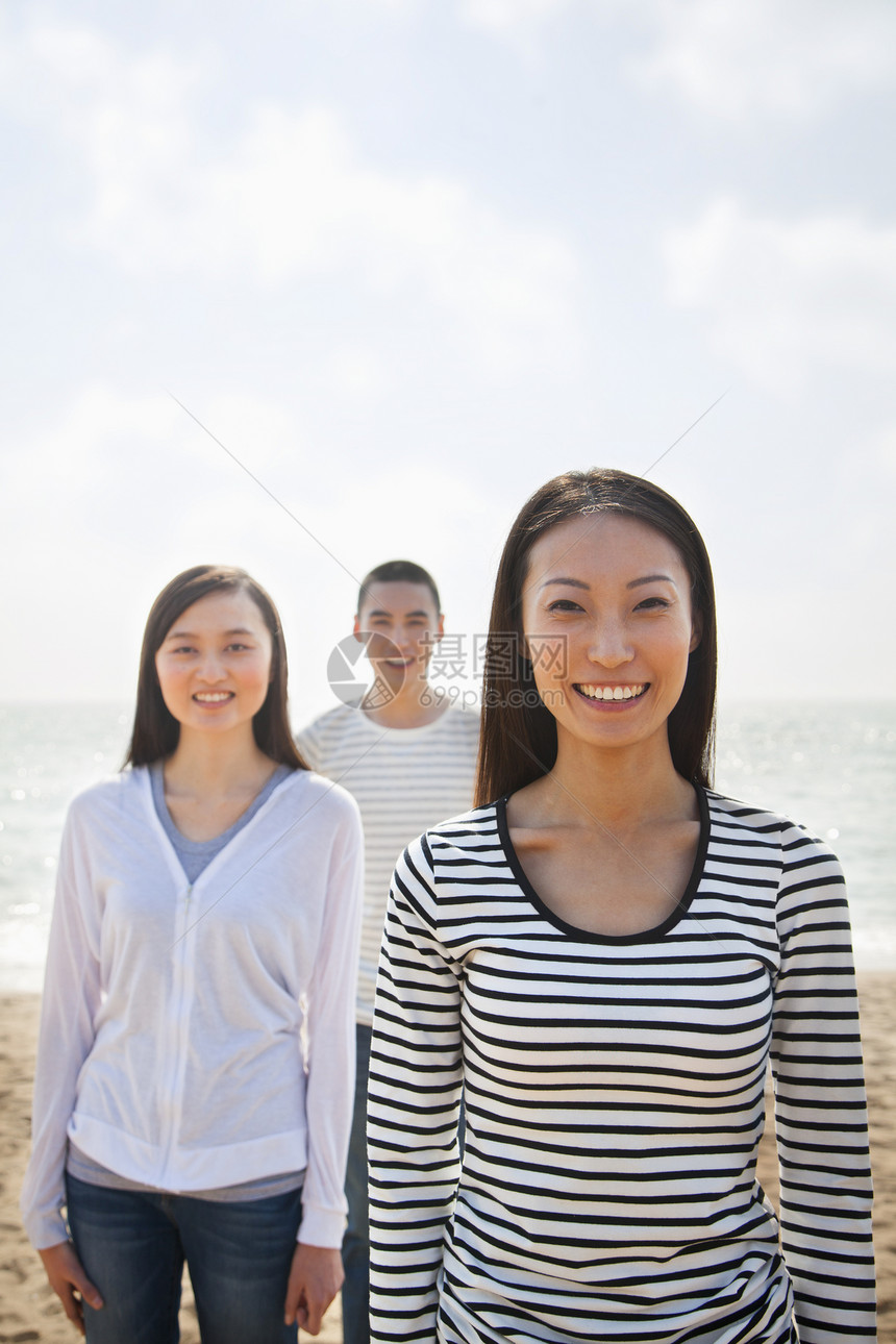 年轻女性的肖像和海滩上的朋友微笑海洋白色友谊休闲天空收腰短发长发活动图片