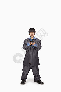 男孩装扮成商务人士 检查手机号码背景图片