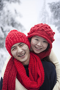 雪中年轻夫妇乐趣服装友谊衣物活动围巾男朋友微笑幸福女性背景图片