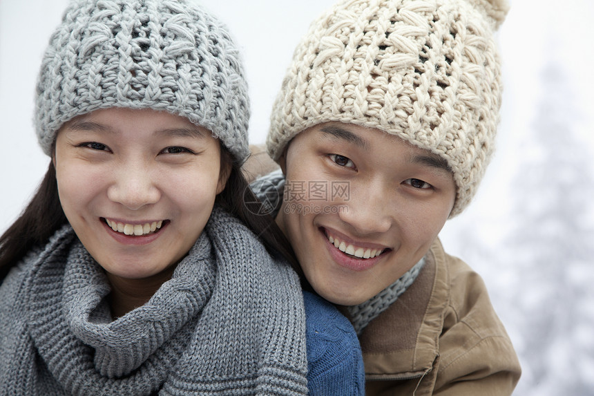 雪中年轻夫妇微笑女朋友男朋友休闲低温团结拥抱幸福友谊活动图片