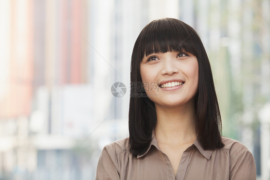 北京市外微笑的年轻女子肖像 仰望着图片