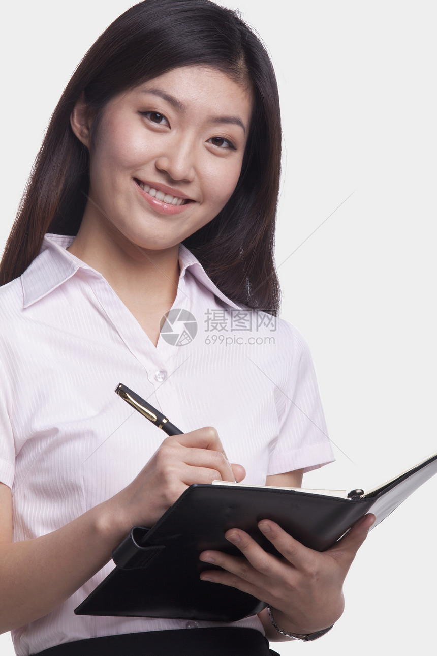 青年女商务人士写作长发对象记事本微笑笔记本棕色商务头发女性纽扣图片