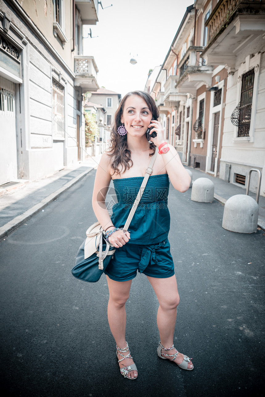 电话上美丽的女人城市手机相机幸福呼唤女士微笑街道沟通图片