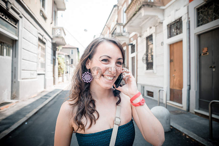 电话上美丽的女人街道呼唤手机沟通微笑城市相机幸福女士图片