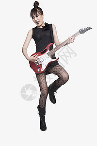 女青年玩吉他叛乱运动电吉他皮革裙子文化主流摇滚摇杆摇滚乐背景图片