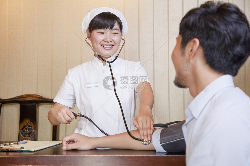 护士检查店员的血压压力帮助医疗女性蓝色考场白色保健测试纽扣收腰图片