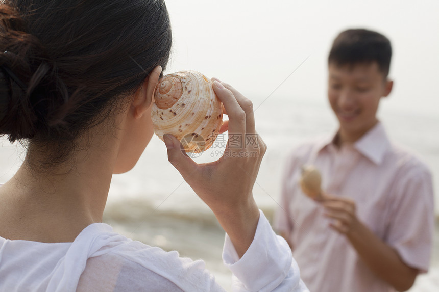 看着贝壳的年轻夫妇 紧紧握着罐壳图片