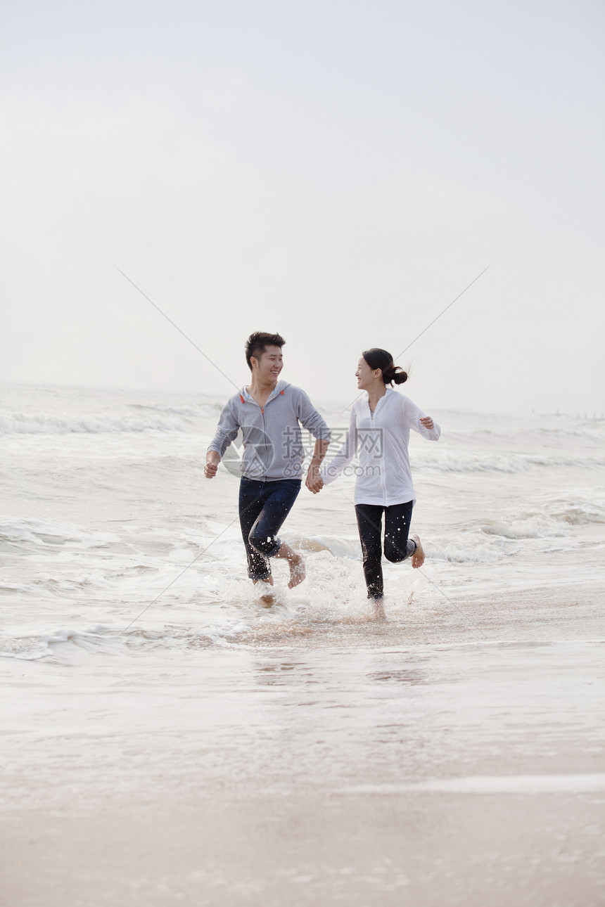 在中国海滩的海边 手牵手跑动的小情侣图片