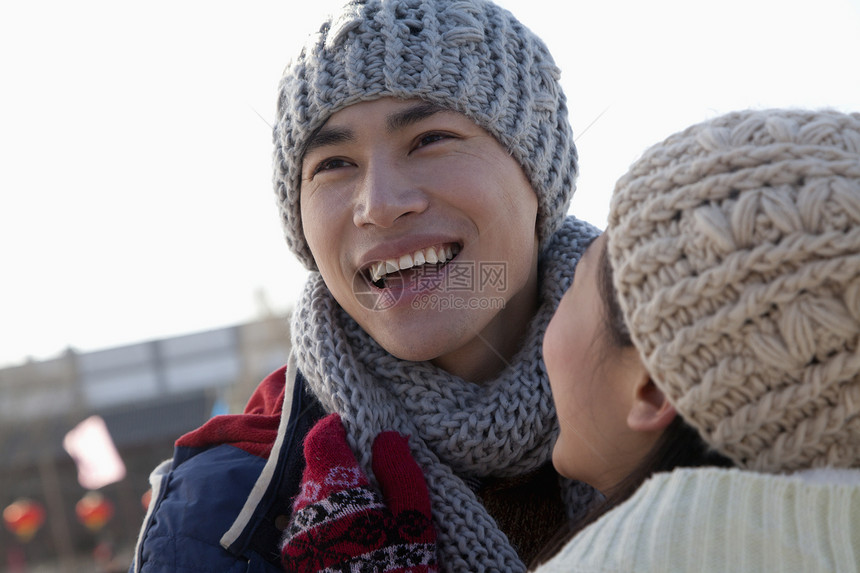 年轻夫妇在溜冰场滑冰年轻人女朋友享受服装拥抱微笑团结摄影男朋友低温图片