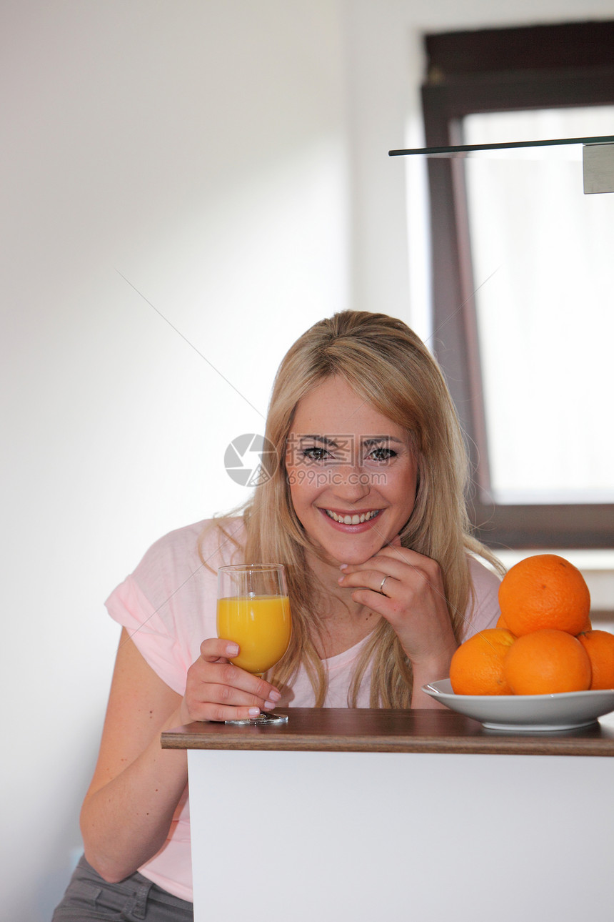 喝橙汁的笑女人玻璃微笑热带橘子橙子饮料女士喜悦金发长发图片