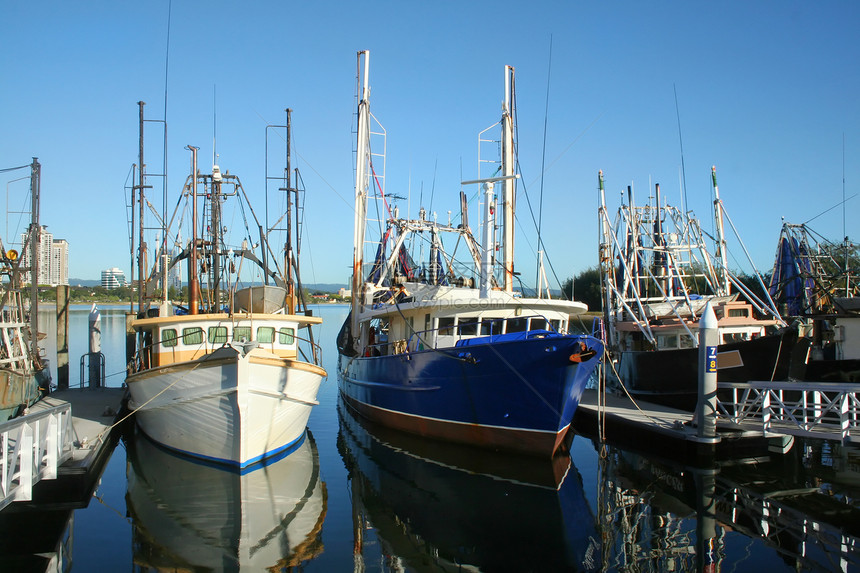 在码头的渔船船船尾日落小艇桅杆天空阳光风景海洋蓝色海景图片