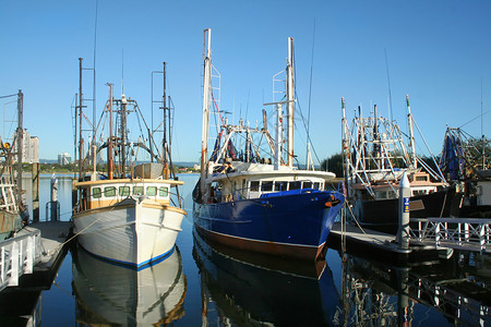 船首楼在码头的渔船船船尾日落小艇桅杆天空阳光风景海洋蓝色海景背景