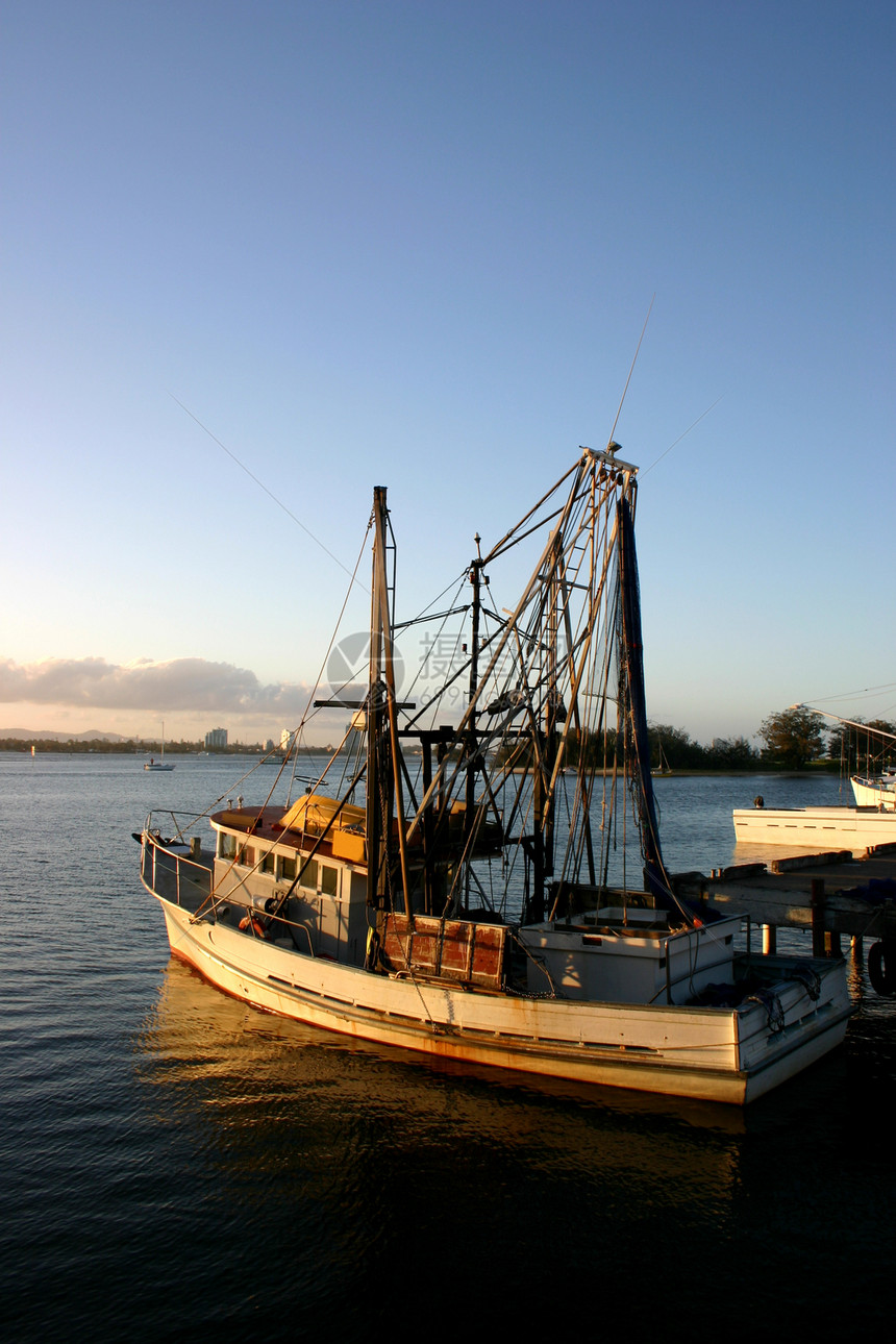 在码头的渔船海景渔业天空蓝色日落远景船尾地平线外表桅杆图片