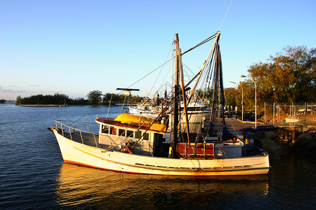 船首楼日落时的拖网鼠索具外表蓝色桅杆船体小艇船只地平线全景远景背景