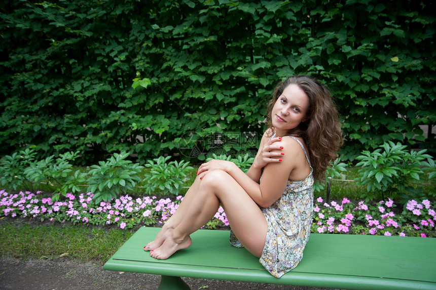 妇女疲倦的双腿阳光赤脚假期绿色感官享受衣服板凳女女性场景图片