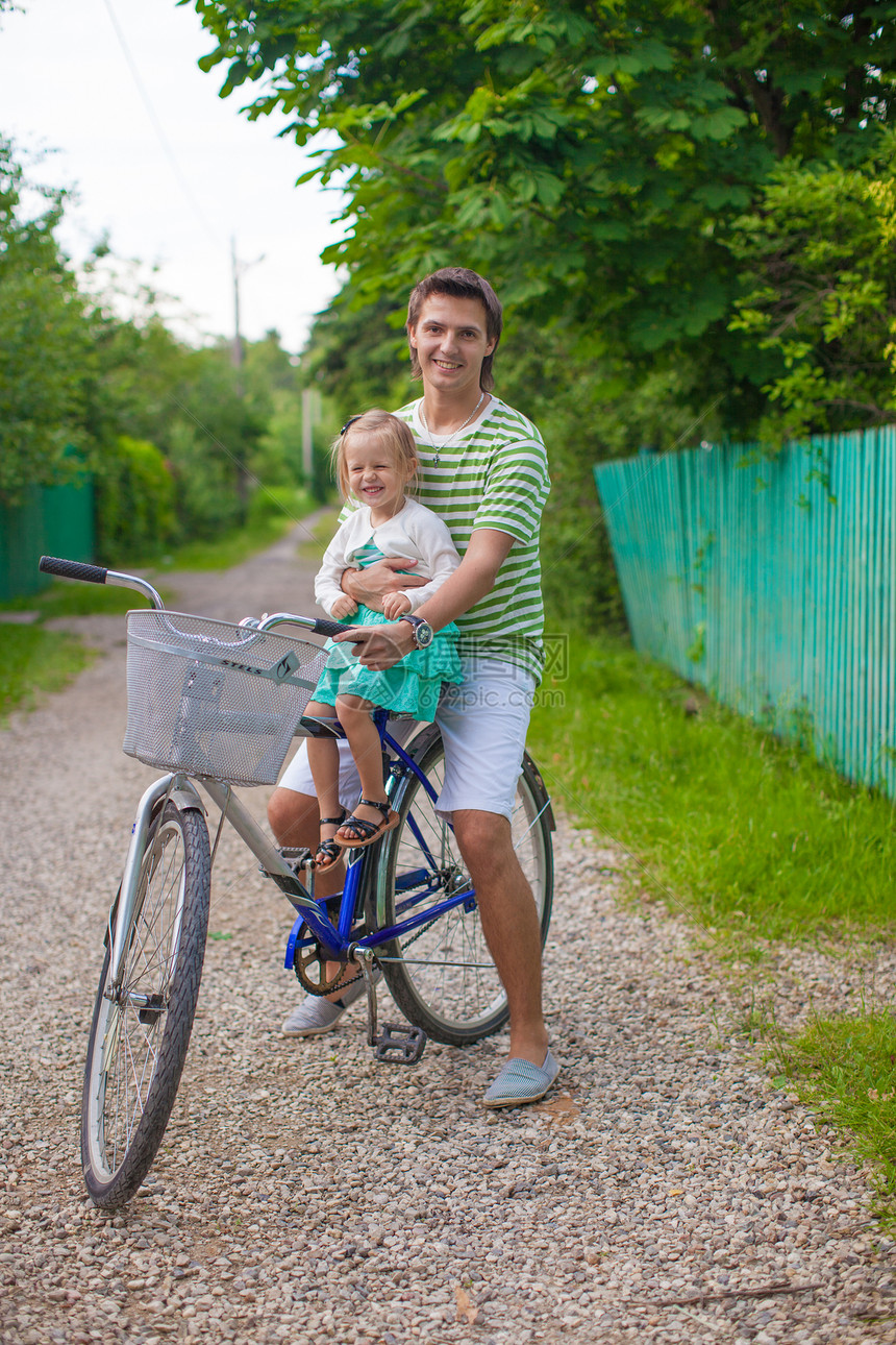 年轻父亲和可爱的小女儿 一起骑单车享受骑术运动孩子微笑自行车成人闲暇男人家庭图片