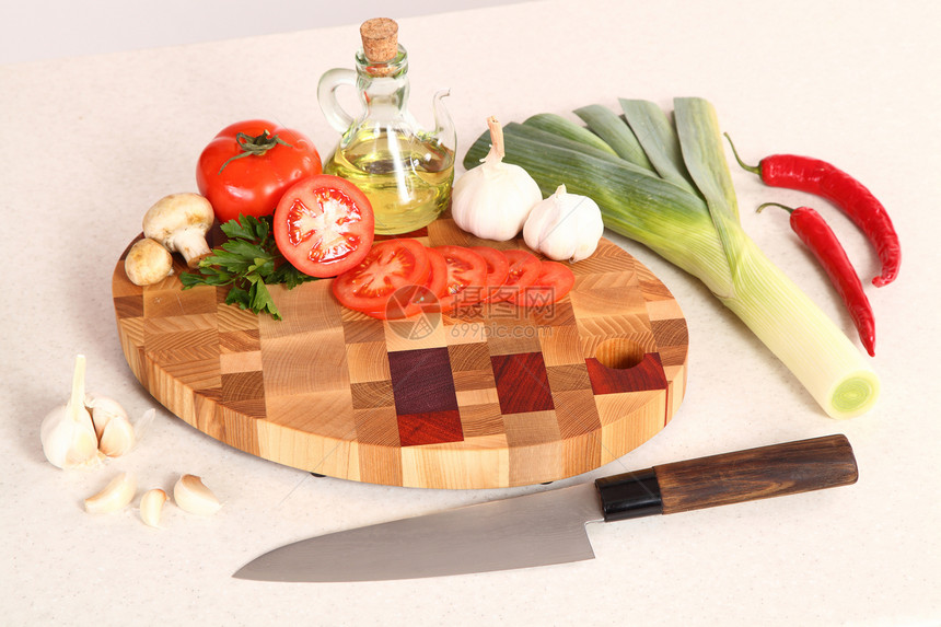 切割板上的产品烹饪胡椒食物木头韭葱红色植物油香菜厨房棕色图片