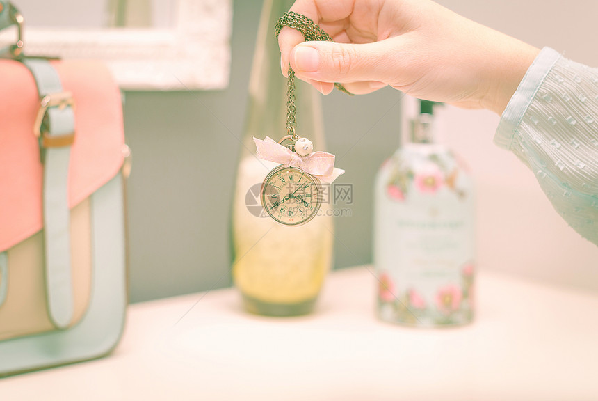 女孩手握着旧时钟项链 在女警察面前珠宝宝石瓶子手提包香味女性香水花朵图片