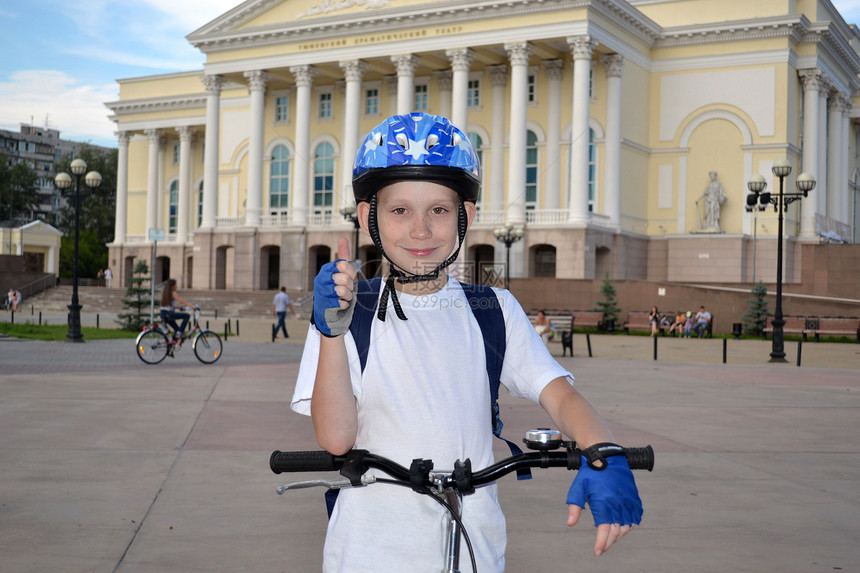 在秋门戏院附近骑自行车的快乐少年图片