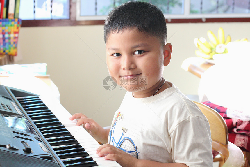 小男孩弹钢琴好玩喜悦男生童年排演键盘衣服孩子音乐合成器音乐家图片