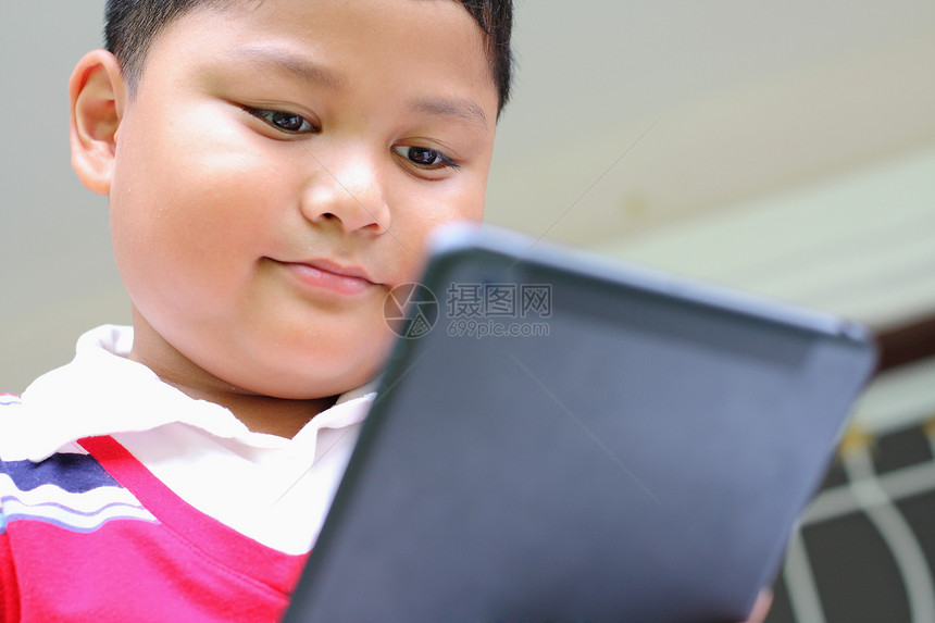 平板男孩玩得开心网络游戏地面闲暇乐趣学习幸福童年触摸屏家庭图片