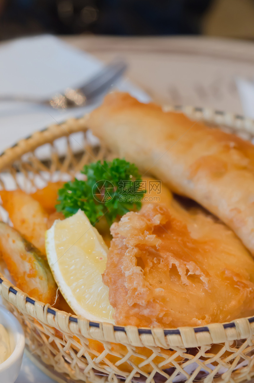 鱼类和芯片油炸鳕鱼柠檬土豆食物黄色香菜棕色海鲜篮子图片