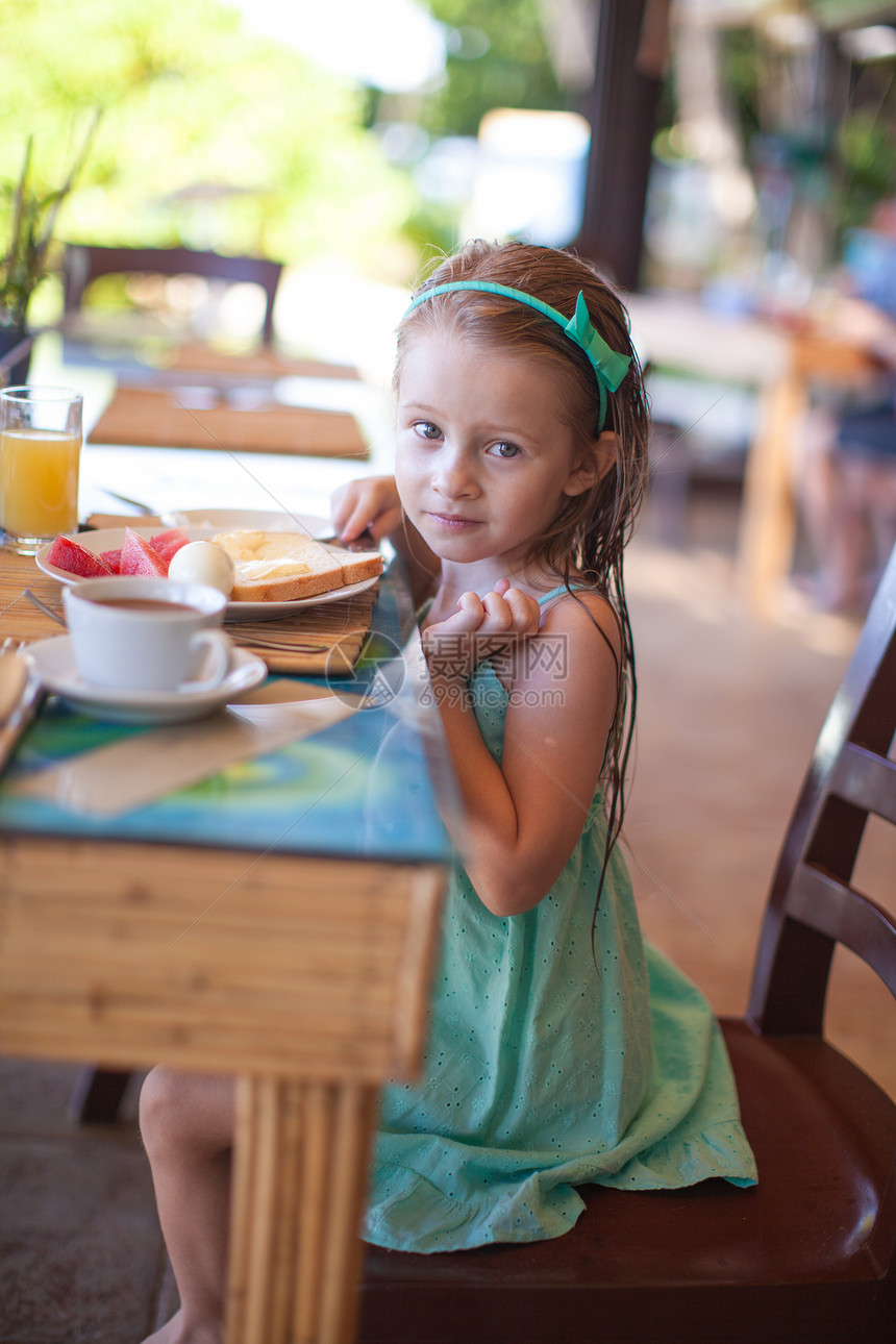 可爱的小女孩在度假餐厅吃早饭 很可爱闲暇时间食物童年快乐酒店青年微笑早餐孩子图片